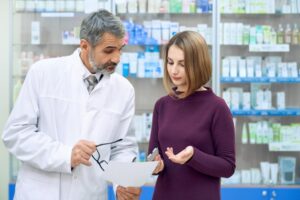 Chemist-explaining-prescription-woman-drugstore